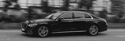 Schwarz-Weiß-Aufnahme der vollständig sichtbaren FRALIMO Mercedes-Benz S-Klasse in Fahrt.