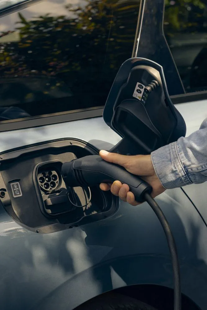 Ein Ladekabel wird an ein Elektroauto angeschlossen.
